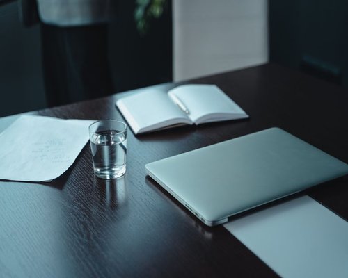 water and notebook on a work desk